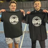 Students holding up championship shirts from a doubles tennis tournament